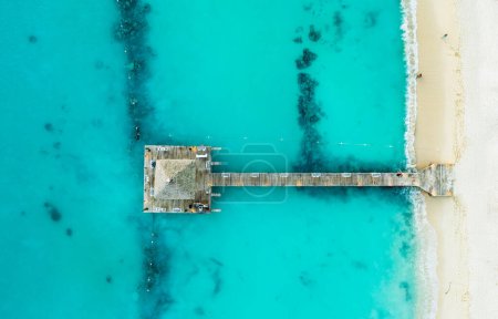 Téléchargez les photos : Belle plage des Caraïbes en République dominicaine. Vue aérienne abstraite du paysage tropical idyllique d'été avec de l'eau de mer bleue, du sable blanc et une jetée en bois - en image libre de droit