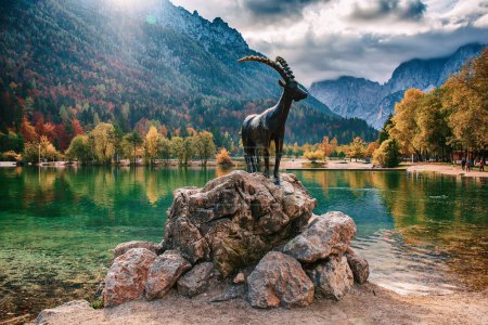 Foto de Jasna lago con el monumento de la cabra de montaña - gamuza Zlatorog en el frente. Parque Nacional de Triglav, Eslovenia - Imagen libre de derechos