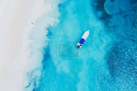 Téléchargez les photos : Belle plage caribéenne sur l'île de Saona, République dominicaine. Vue aérienne abstraite du paysage estival idyllique tropical avec de l'eau de mer bleue, du sable blanc et un seul bateau - en image libre de droit