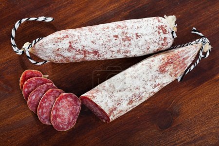 Spanish longaniza sausages cut in slices on a wooden surface, close-up