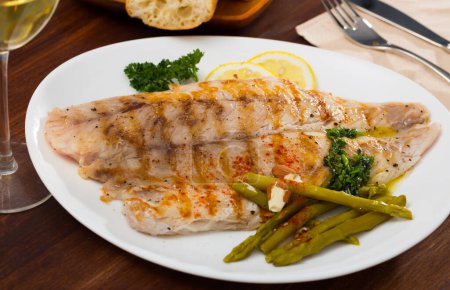 Roasted perch fish fillet served with pickled asparagus and parsley