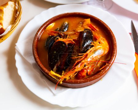 Hearty and spicy Parihuela - Peruvian seafood soup with mussels and prawns..