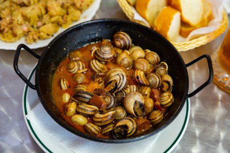 Cooking grape snails in spicy sauce. Traditional spanish dish. High quality photo
