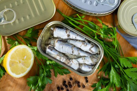 Meeresfischkonserven, Sardinen in Öl, serviert mit Kräutern und Zitrone