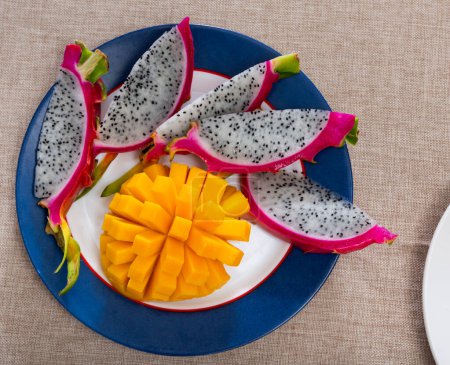 Reife Mangostücke und dünne Scheiben Drachenfrucht in einem Teller aufgetischt
