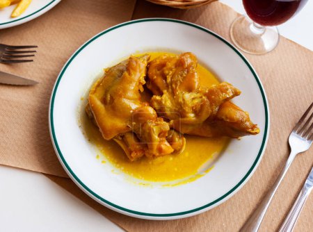 Appetizing stewed pork trotters in gravy. Typical meal of Andalusian cuisine..