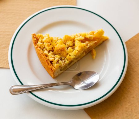 Delicious homemade apple pie with crumbly topping on plate. Popular sweet pastries.