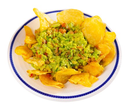 Beer snacks are laid out on plate - chips and portion of thick pasta sauce guacamole. Traditional Mexican snack at national restaurant. Isolated over white background