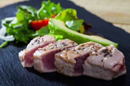 Lightly roasted tuna fillet with fresh avocado and greens