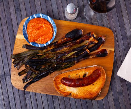 Popular Spanish snack is delicious calsot with Romesco sauce, and traditional butifarra sausage served on toast