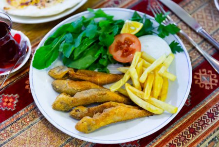 Frittierte Meeräsche mit Gemüsegarnitur, serviert in einem authentischen türkischen Restaurant.
