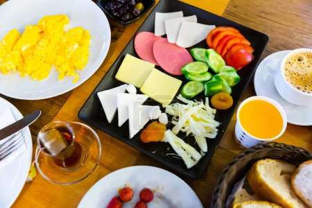 Halal-Frühstück im Hotel mit einem köstlichen Omelett, Käse, Wurst, gehacktem Gemüse, Oliven, Brot und Obst.