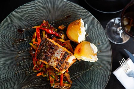 Appetizing juicy fried salmon steak with stewed vegetables on a plate
