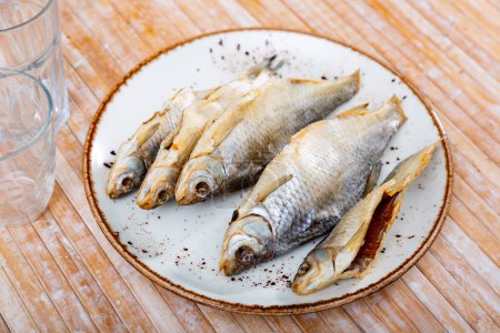 Dried salted fish roach, lying on a plate. High quality image