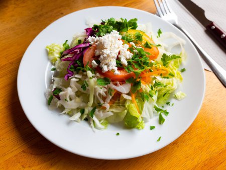 Köstlicher Salat aus frischen Salatblättern, Tomaten, Mais, Zwiebeln, geriebenen Karotten und Petersilie mit Quark.