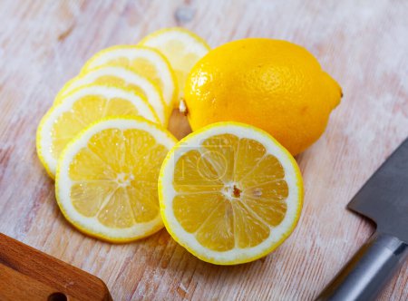 Frische, saftige Zitrone in Scheiben geschnitten auf einem Holztisch. Konzept der gesundheitlichen Vorteile von Zitrusfrüchten