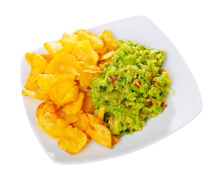 Beer snacks are laid out on plate - chips and portion of thick pasta sauce guacamole. Traditional Mexican snack at national restaurant. Isolated over white background