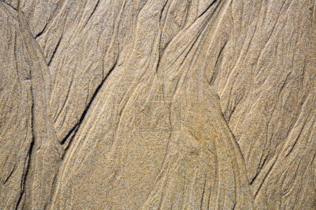 Nahaufnahme von Mustern auf dem Sand aus dem Meerwasser nach Ebbe, Spanien
