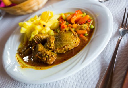 Juicy baked chopped pork cheeks served with potato and vegetables