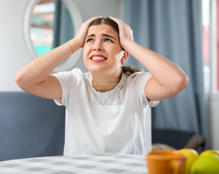 Screaming displeased young woman splashing out emotions at home