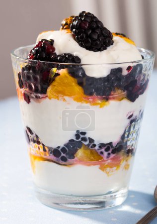 Leichtes Dessert mit weißem Joghurt, Maulbeere und frischer Orange im Glas