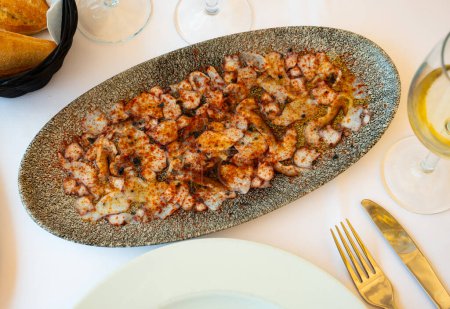 Köstliches Oktopus-Carpaccio gewürzt mit aromatischem Öl und geräuchertem Paprika auf Teller serviert. Vorspeise mit Meeresfrüchten