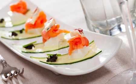 Bild von frischem Salat mit Lachs, zwei Käsesorten und frischer Gurke