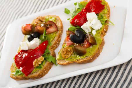 Delicious sandwiches with guacamole, fresh tomatoes, sweet pepper and feta cheese.