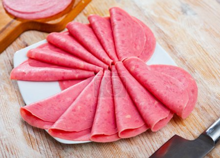 Slices of sausage mortadella from turkey on cutting board