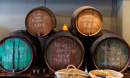 Katalanische Weinhandlung bietet verschiedene Fassweine aus Holzfässern an..
