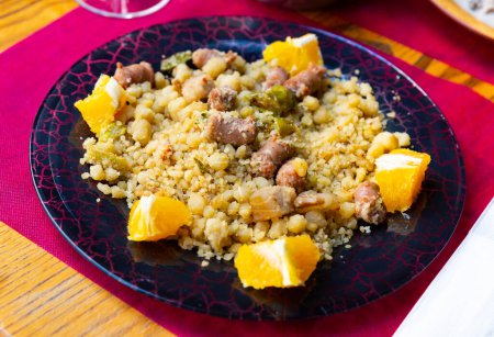 Typisches spanisches Gericht aus Grießmehl mit Longaliza-Wurst, serviert mit Orange