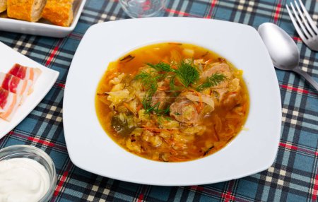 Russische Küche. Beliebte nationale Shchi gekocht aus Sauerkraut in Pilzbrühe mit Schweinefleisch serviert mit saurer Sahne