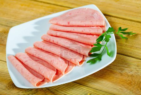 Traditionelle Kochwurst aus gehacktem Schweinefleisch in dünne Scheiben geschnitten auf Holztisch