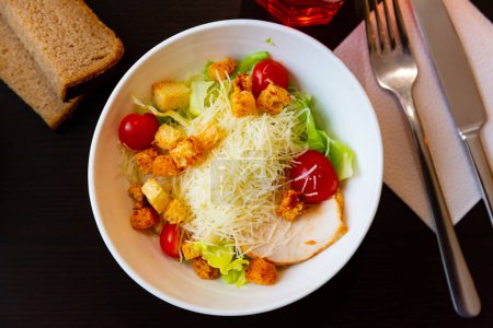 European cuisine, healthy grilled chicken Caesar salad with tomatoes, cheese and croutons
