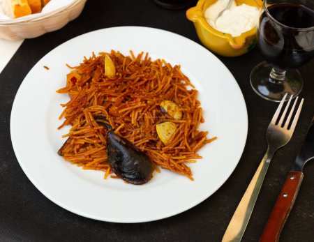 Spanische Paella mit Pasta Fideua mit verschiedenen Meeresfrüchten und Aioli-Sauce