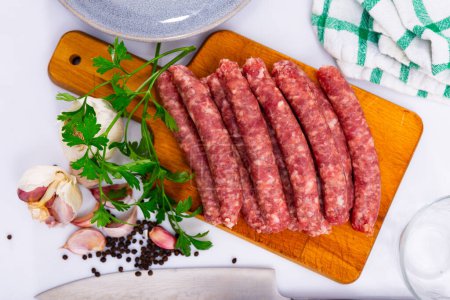 Fresh sausages longaniza on chopping board in restaurant. Catalan dish