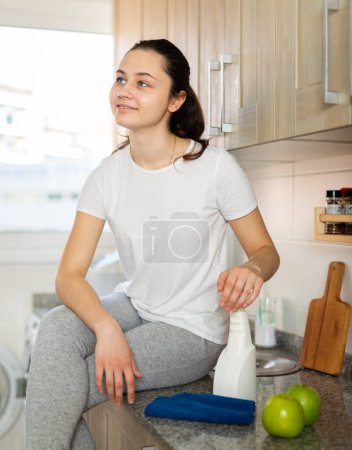 Femme avec chiffon nettoyage table de cuisine à la maison