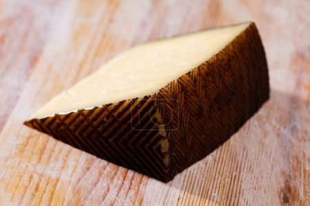 Delicious semi-hard cheese on wooden table. High quality photo