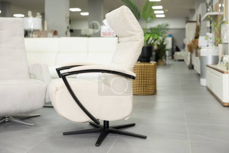 Comfortable ergonomic modern soft office chair with white suede and leather upholstery, black metal armrests and chair base, displayed for sale in furniture store