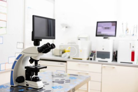 Microscope with multiple magnification, additional liquid crystal monitor screen are installed on desktop. Modern equipment with diagnostic equipment of veterinary clinic laboratory.