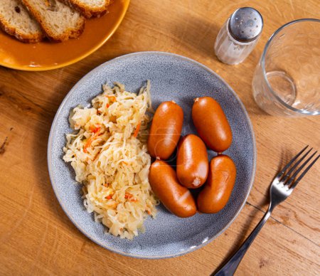 Appetizing sausages with side dish of sauerkraut