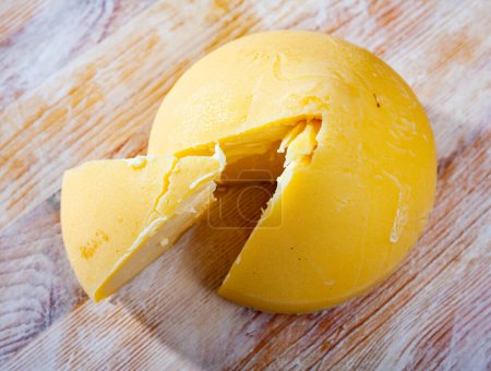 Cabeza de famoso queso Tetilla gallego en forma de cono sobre mesa de madera