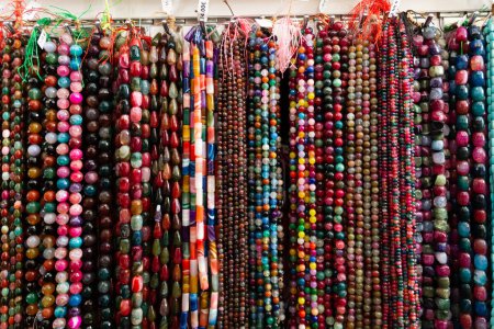 Strands of multicolored semiprecious stones offered for sale on display in bijouterie store