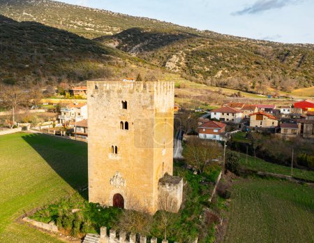 Hochmittelalterlicher, mehrstöckiger Valcedoceda-Turm inmitten grüner Hügel und Wälder, Spanien. Antiker mittelalterlicher Bau, Verteidigungshaus