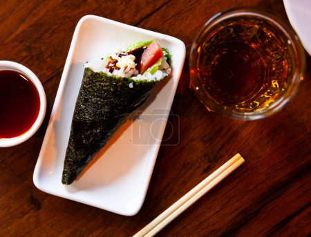 Köstliches Temaki-Sushi mit Thunfisch und Avocado mit Mayonnaise. Beliebte japanische Handrolle