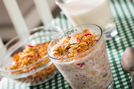 Glass of milk with muesli and dried fruits