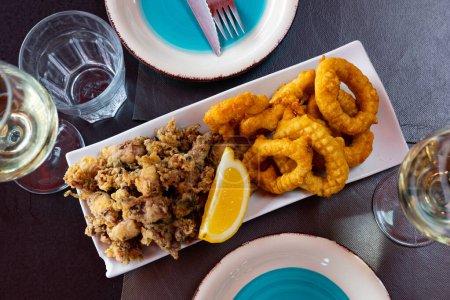 Popular appetizer of Spanish cuisine is squid a la romana and baby andalusian squids served with a slice of lemon