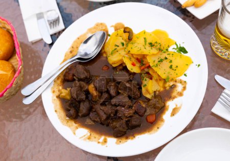 Appetizing stew of port wine with thyme and mushrooms, served in the Toledo region. Served with boiled potatoes and ..garnished with fresh chopped herbs