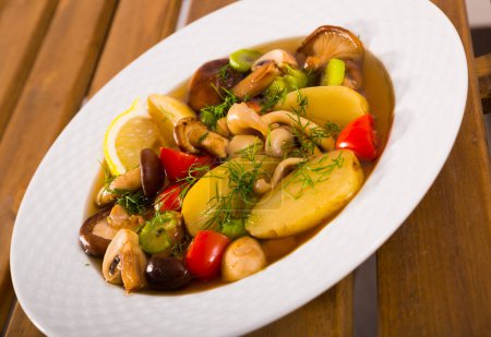 Mushroom soup prepared with boiled potatoes, shitake, tomatoes and greens