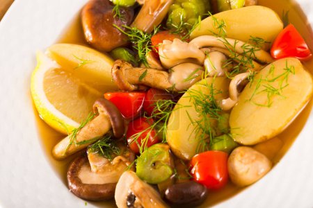 Pottage rustique cuit avec des champignons et des légumes servis avec une tranche de citron ..